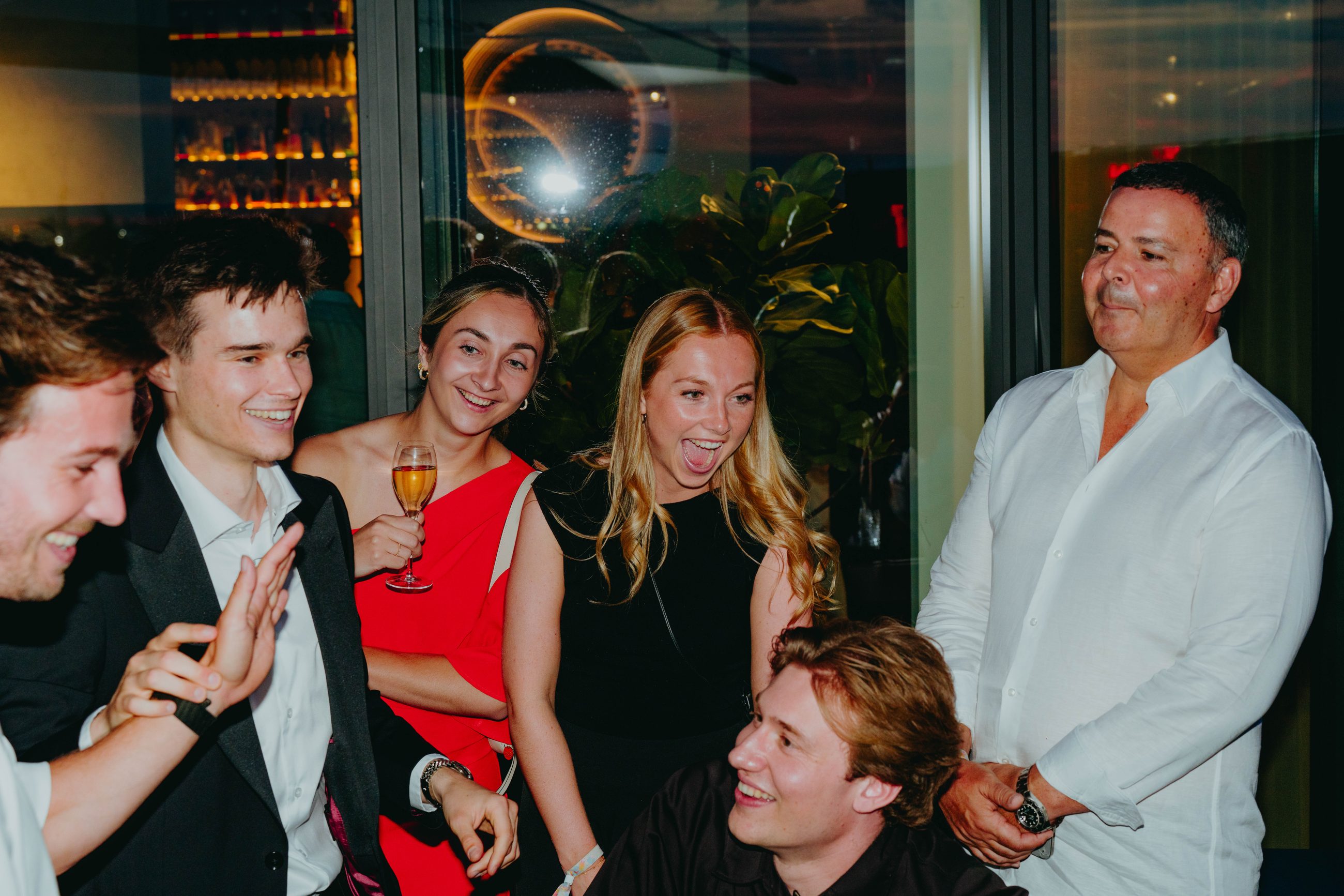 A group of guests reacting with astonishment during a rooftop event performance