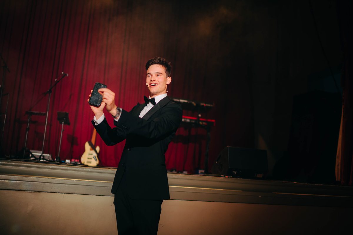 Jonas De Bruyn in black tie on a theatre stage