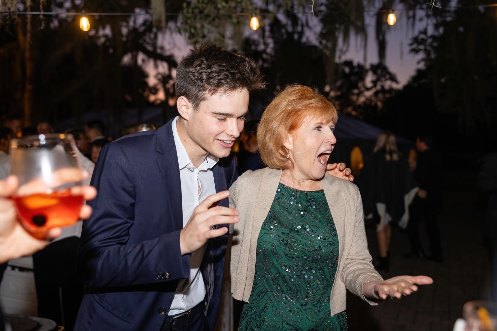 A guest reacting with wide-eyed astonishment at an outdoor evening party