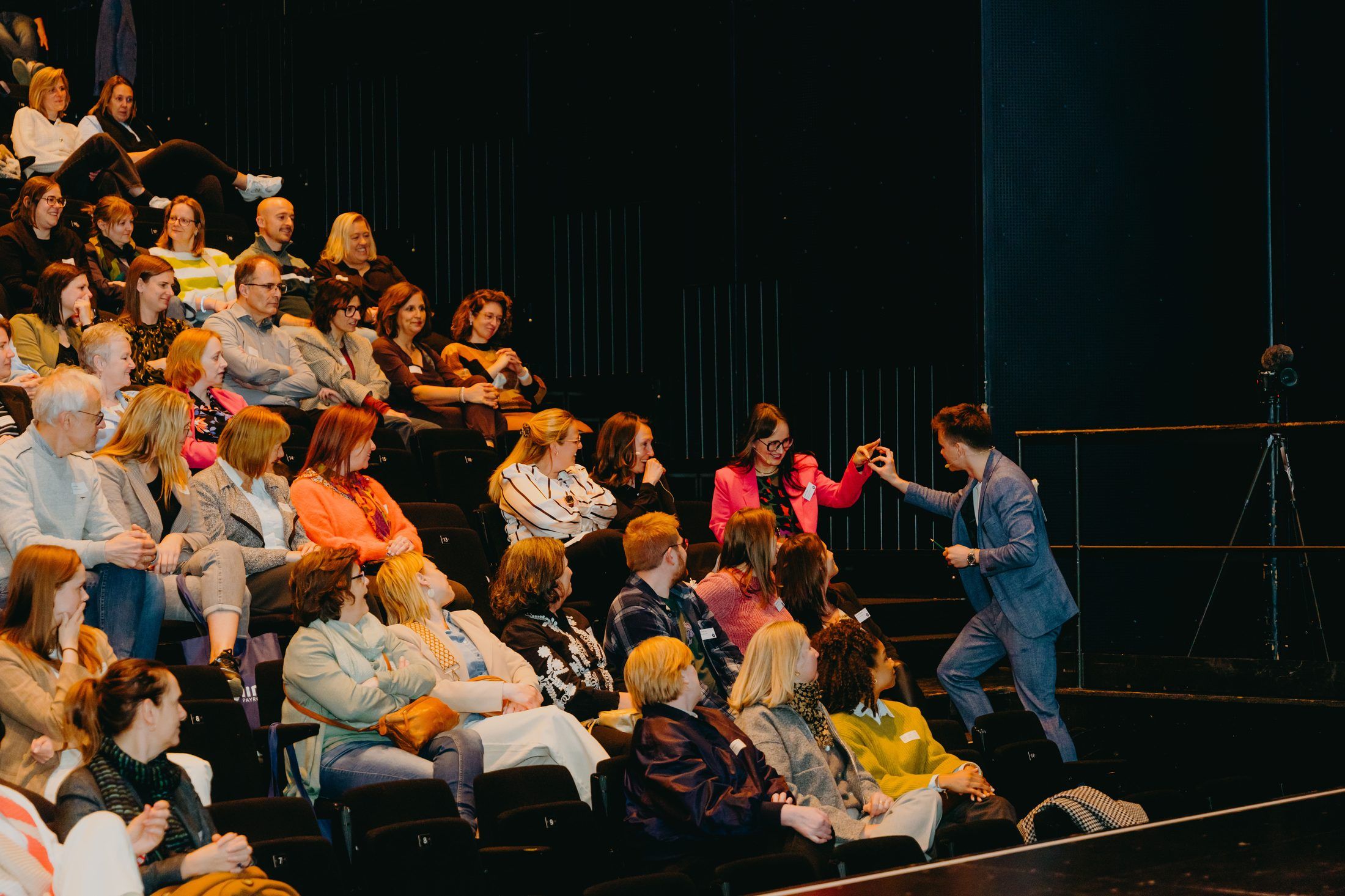 Jonas De Bruyn connecting with a delighted audience member in a full theatre